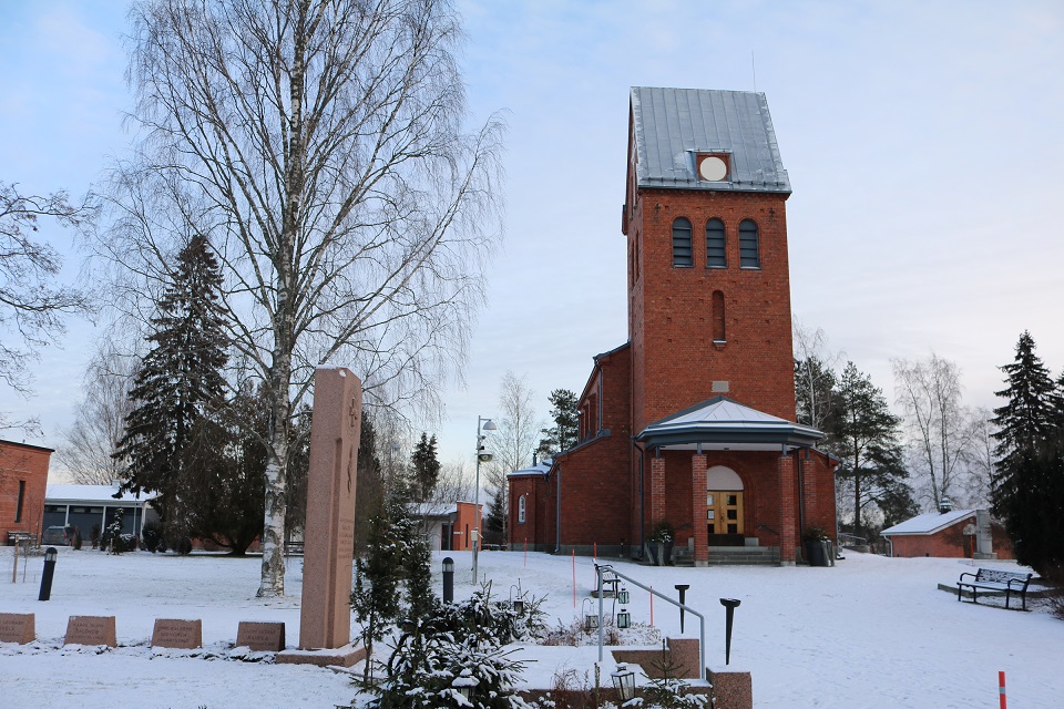Vanha kirkko ja pala hautausmaata talvella.